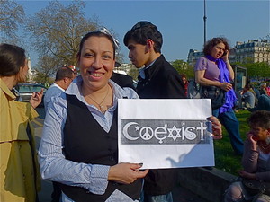 Une jeune femme arabe brandit sa pancarte "Coexist" lors de la Marche silencieuse contre le racisme, le 25 mars 2012 à Paris.